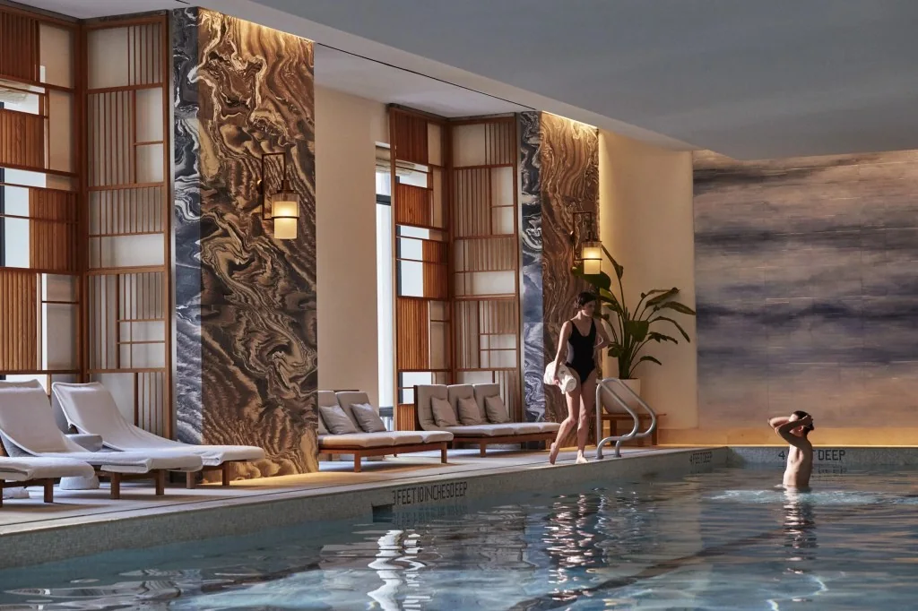 Indoor pool with wood screens and marble columns at Club 27