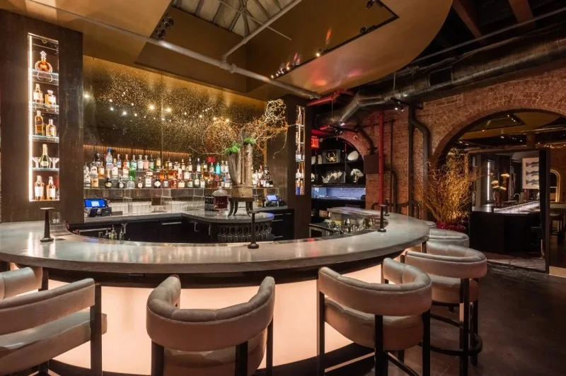 Curved bar and plush stools at Zero Bond in New York
