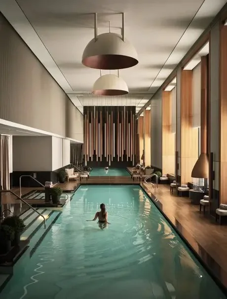 Indoor swimming pool with warm lighting at Aman New York